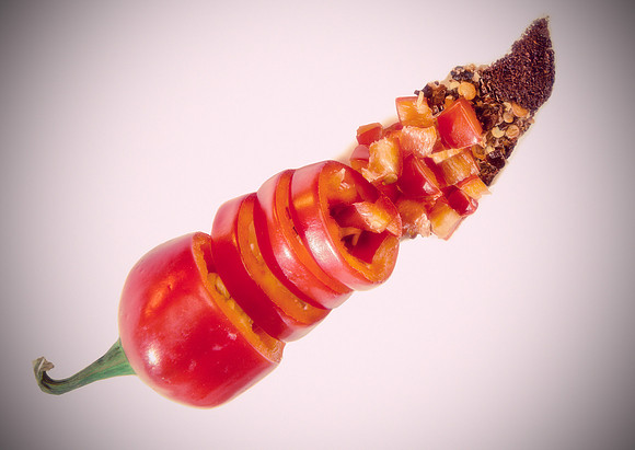 Conceptual image for the various ways in which we consume red chilis. Whole, sliced, diced, crushed, and ground.