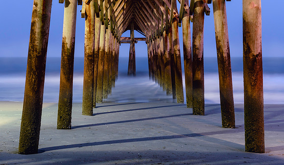 Underneath Pier 14 in Myrtle Beach, South Carolina at twilight.