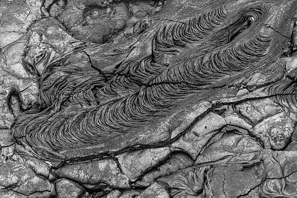 Pahoehoe lava flows from Pu'u O'o crater have cooled in this case the cooled lava looks like billowy scarf hooked on something in a breeze.