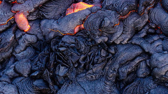 Pahoehoe lava flows from Pu'u O'o crater on Kilauea Volcano's southeast rift zone. The lava has taken almost organic looking shapes.