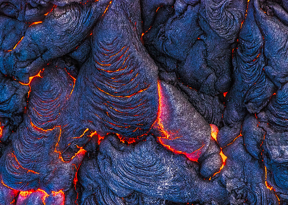 Pahoehoe lava forms lobes over top of itself as it slowly pushes forward, cools, and then pushes forward again.