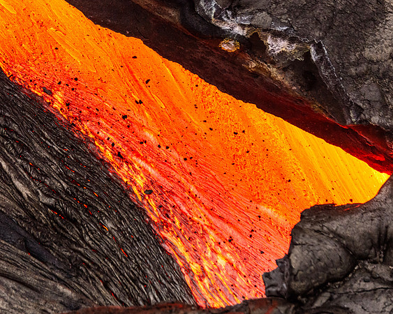 Pahoehoe lava flows from Pu'u O'o crater on Kilauea Volcano's southeast rift zone. Taken overhead from a helicopter. In this particular image lava slows at  sharp bend in the lava tube which shows thr