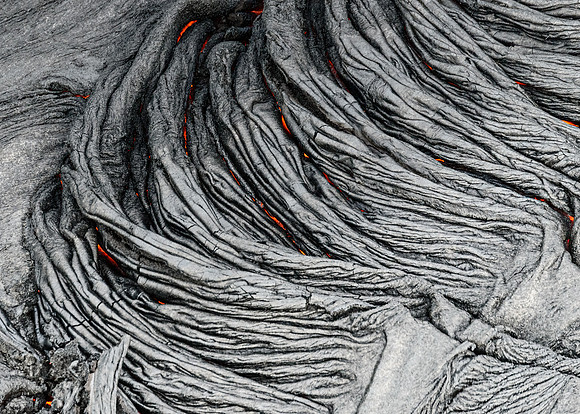 Pahoehoe lava flows from Pu'u O'o crater on Kilauea Volcano's southeast rift zone. This lava cooled forming a ropy texture.
