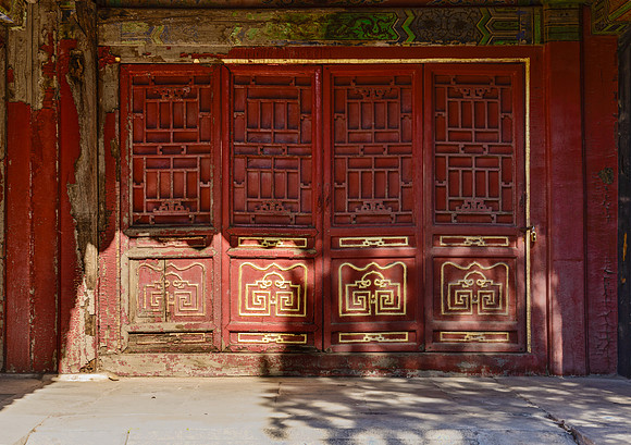 Original wooden doors still with gold leaf at the Forbidden City in Beijing, China.
