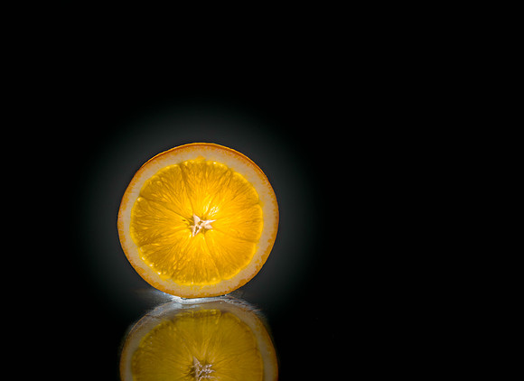 Just a slice of orange backlit with the reflection in the foreground.
